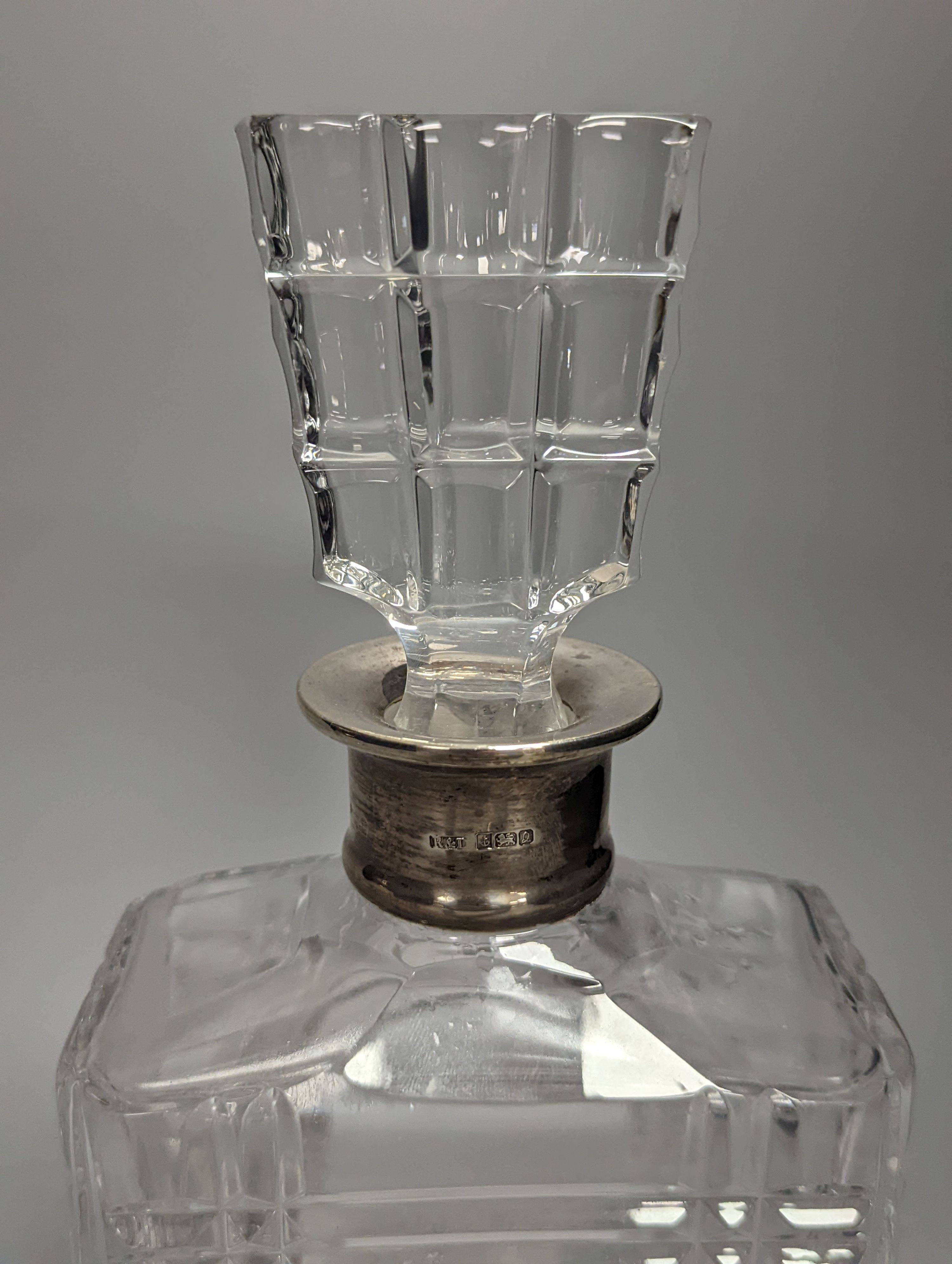 A pair of silver mounted cut glass decanters, with mis-matched stoppers